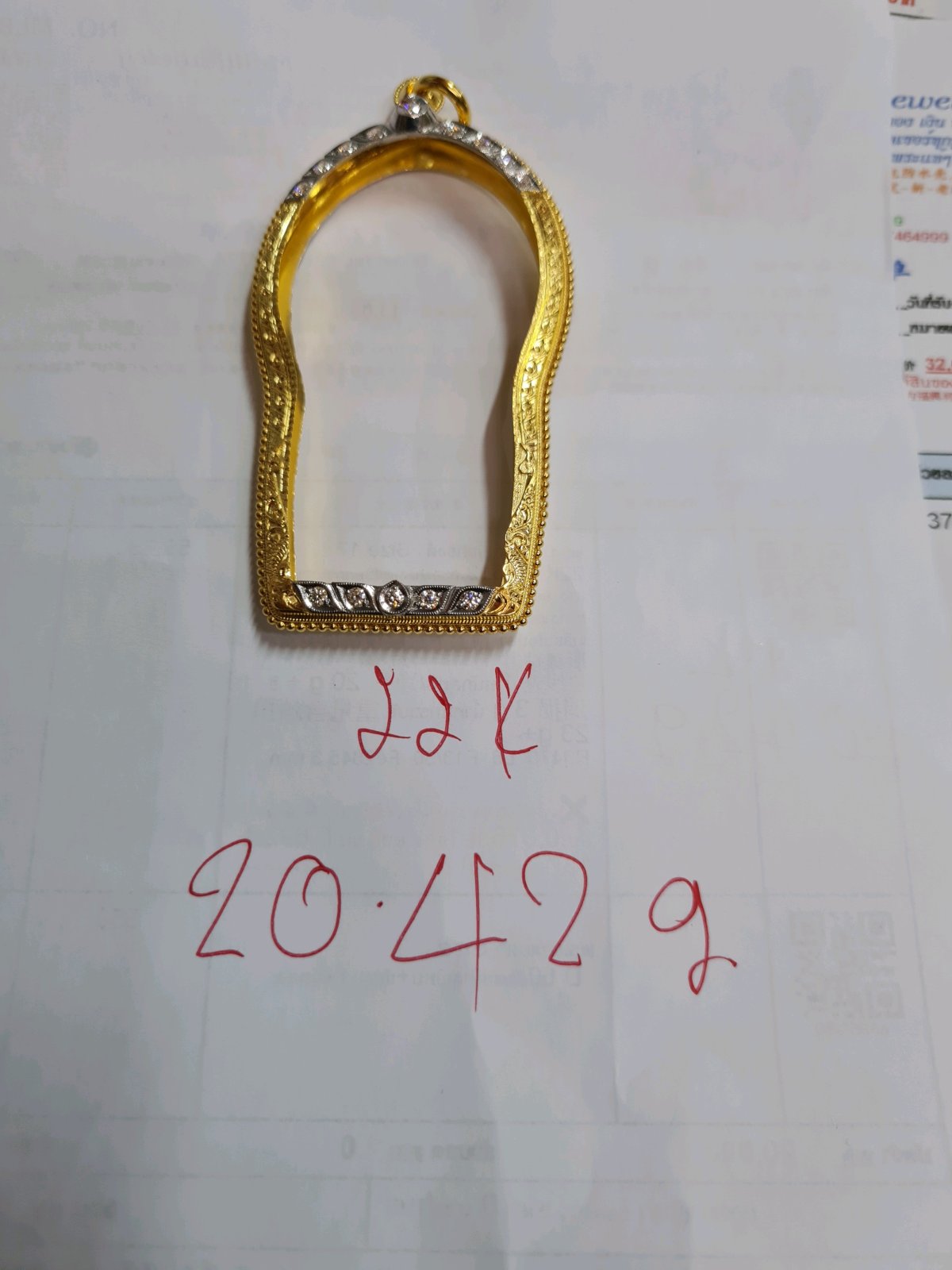 กรอบฝังเพชรยกกระเบาะบนล่าง ยอดบนทางยอดน้ำใหญ่ หูติดลวดเกลียว ตรงกลางและแผ่นหลังแกะลายไทยแข้งสิงห์ ข้างลวดเกลียวไข่ปลา